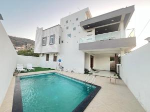 a villa with a swimming pool and a house at Sunset view Villa 966o9o1oo6 Luxury 5BHK Villa with pool in Nathdwara 2km from temple only By SK in Nāthdwāra
