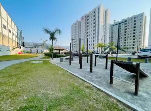 a row of benches in a park with tall buildings at Apto, Moderno - perto da WEG in Jaraguá do Sul