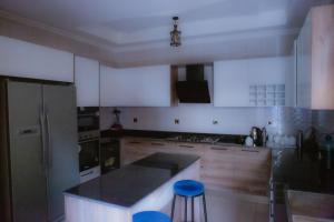 a kitchen with white cabinets and a black counter top at KIGALI FANTASTIC APARTMENT airport Road in Kigali