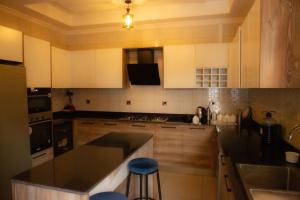 a kitchen with white cabinets and a black counter top at KIGALI FANTASTIC APARTMENT airport Road in Kigali +27 photos