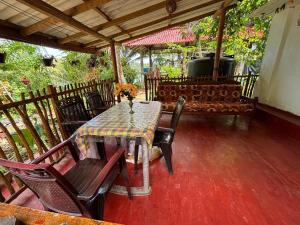 a table and chairs on a porch with a grill at Surf Paradise in Tangalle