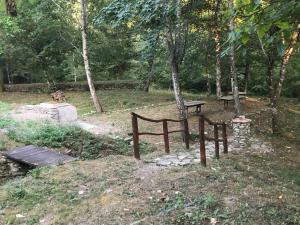 a park with a bench and a table and trees at Casa Vacanze MULINO DI VALIANA in Pratovecchio