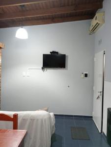 Habitación con pared blanca y TV en la pared. en Sito y Pocha 2, en Veinticinco de Mayo