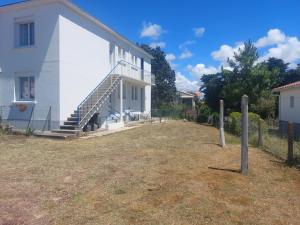 ein weißes Haus mit einer Seitentreppe in der Unterkunft Notre Dame de Monts proche plage in Notre-Dame-de-Monts