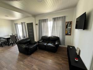 a living room with two leather chairs and a table at Paz&Mar in Mar del Sur