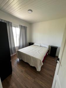 a bedroom with a bed and a large window at Paz&Mar in Mar del Sur