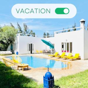 - une piscine en face d'un bâtiment blanc avec des chaises jaunes dans l'établissement RELAXING EXPERIENCE In ESSAOUIRA-VILLA OLIVE, à Essaouira