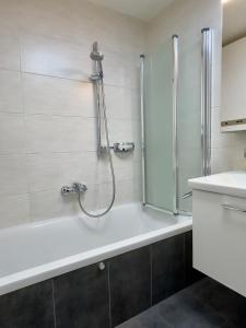 un baño con ducha y bañera en Zentrales Apartment in Seefeld, en Seefeld in Tirol 17 fotos más