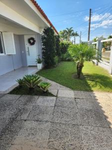 a house with a walkway in front of a yard at Casa veraneio em Xangri-Lá in Xangri-lá