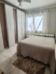 a bedroom with a large bed and a window at Casa veraneio em Xangri-Lá in Xangri-lá +26 photos