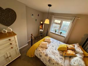 a bedroom with a bed with pillows and a window at Fitzherbert Cottage in Swynnerton