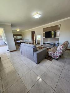 a living room with a couch and a television at Casa veraneio em Xangri-Lá in Xangri-lá