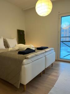 a bedroom with a large bed and a large window at Bohemian Luxury with private Sauna, own carparking, 3 km from airport in Vantaa