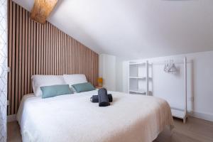 une chambre avec un grand lit blanc avec une tête de lit en bois dans l'établissement Lideale Studio - Air-conditioned - 4 min Gare matabiau, à Toulouse