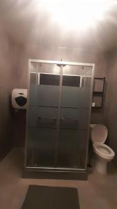 a bathroom with a toilet and a glass wall at La closerie aux écureuils in Limeux +10 photos