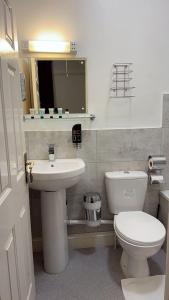 a bathroom with a white toilet and a sink at Regency Hotel in Leicester +27 photos