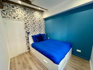 ein blaues Zimmer mit einem Bett mit blauer Wand in der Unterkunft Le Bleuet de Rouen in Rouen
