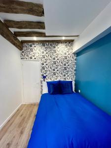 ein blaues Bett in einem Zimmer mit blauer Wand in der Unterkunft Le Bleuet de Rouen in Rouen