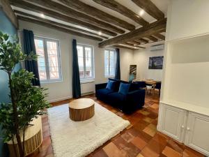 ein Wohnzimmer mit einem blauen Sofa und einem Tisch in der Unterkunft Le Bleuet de Rouen in Rouen