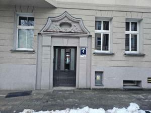 a door of a house with snow in front of it at Apartament Czołgistów Centrum in Lębork +1 photo