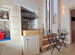 a small kitchen with a table and chairs in a room at IL PLEBISCITO luxury in centro per davvero in Martina Franca