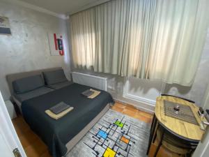 a small bedroom with a bed and a table at Apartmani Vrabac 4 in Divčibare