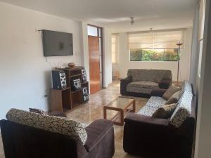 ein Wohnzimmer mit zwei Sofas und einem Fernseher in der Unterkunft Departamento cerca a Cerro Azul in Hualcará