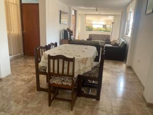 ein Wohnzimmer mit Tisch und Stühlen und einer Couch in der Unterkunft Departamento cerca a Cerro Azul in Hualcará