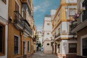 an alley in an old town with buildings at Sevilla DosTorres in Seville