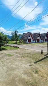 an empty street with two houses in the background at Penginapan & Homestay Ratu Pantai Geopark Ciletuh in Cikadal