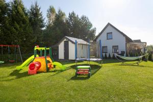 un parco giochi con un'altalena e un'amaca in un cortile di Pod Sosnami a Jarosławiec