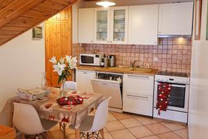 a kitchen with a table and white appliances at Le Chalet des Séraphins in Saint-Sorlin-dʼArves