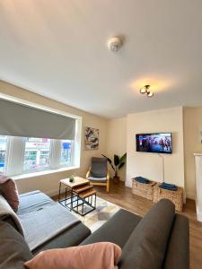 Una sala de estar con un sofá y un televisor. en DVMescape flat1, en Bristol