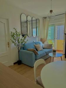 un salon avec un canapé bleu et une table dans l'établissement Vistas al mar primera linea playa Valdelagrana, à El Puerto de Santa María 39 autres photos