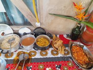 ein Tisch mit vielen verschiedenen Speisen darauf in der Unterkunft Jundu Hospitalidade e Arte in Itanhaém