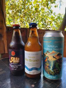 drei Flaschen Bier auf einem Tisch in der Unterkunft Jundu Hospitalidade e Arte in Itanhaém