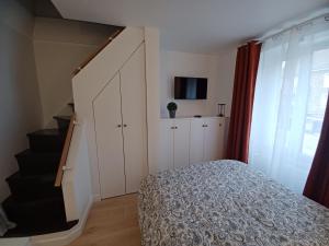 een slaapkamer met een bed en een trap bij La Demeure du Chevalier in Saint-Cyr-lʼÉcole +3 foto's