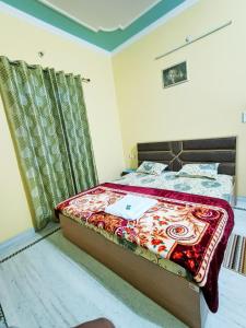 a bedroom with a bed and a window with a bedspread at Shri Ganesh Homestay in Prayagraj