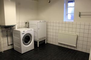 a laundry room with a washing machine and a window at Solbacken in Bjärred