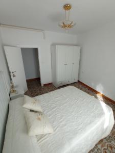 a bedroom with a large white bed and a chandelier at Jaén Ways in Jaén +7 photos