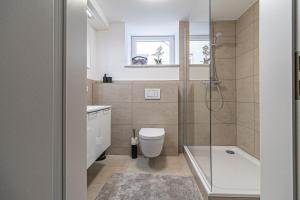 un baño con inodoro y ducha en FeWoMo Stilvolles EG Appartment, Brauneberg, 4 Pers, Boots Slipanlage, Moselradweg, Seniorengerecht, en Brauneberg 17 fotos más