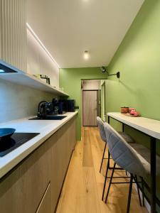 a kitchen with green walls and two bar stools at Jacuzzi Old Town Escape in Bucharest +37 photos
