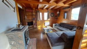 a living room with a couch and a stove at Chalet Cosy avec terrasse plein sud, 2 chambres, au cœur de la Haute-Savoie in Châtillon-sur-Cluses