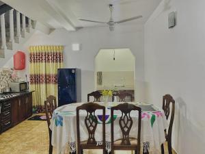a dining room table with chairs and a kitchen at Fantasia Residence in Wattala