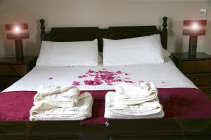 un letto con asciugamani bianchi e fiori rosa di Cowshed - Duffys Ballybin 4-star a Ashbourne