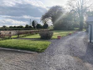 una strada sterrata con una recinzione e dell'erba di Cowshed - Duffys Ballybin 4-star a Ashbourne