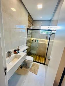 a bathroom with a toilet and a sink and a shower at Casa disponível para a COP in Ananindeua