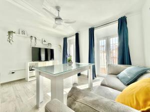 a white living room with a table and a couch at Villa Tortola II in Antequera