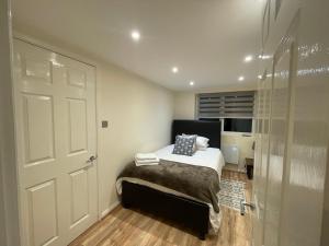 a bedroom with a bed and a glass door at The Cosy Cottage, Old Soles bridge Lane in Chorleywood