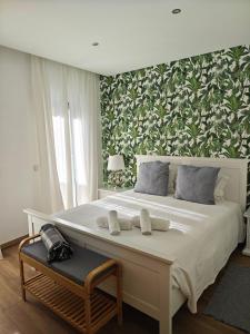 een slaapkamer met een groot wit bed en een groene muur bij The Old Town House by Freetimealgarve in Faro